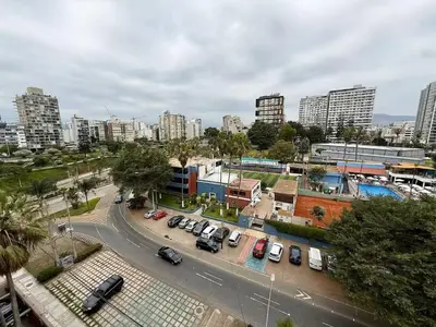 a city with cars parked in a parking lot at Departamento San Martin in Lima