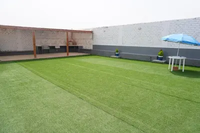a large artificial lawn with an umbrella in a building at Apartamento 301 cerca a la playa in Punta Negra