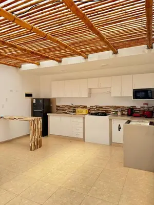 a large kitchen with white cabinets and a black refrigerator at Apartamento 302 cerca a la playa in Punta Negra