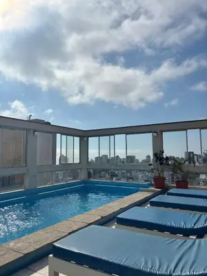 a swimming pool on the roof of a building at Acogedor departamento en Malecón Balta con Piscina in Lima