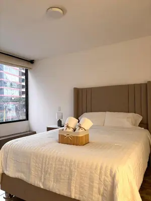 a bedroom with a large bed with two pillows on it at Acogedor departamento en Malecón Balta con Piscina in Lima