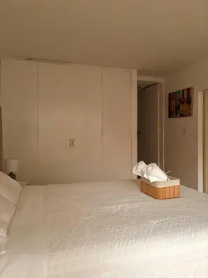 a white bed with a box of towels on it at Acogedor departamento en Malecón Balta con Piscina in Lima