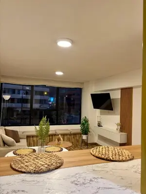 a living room with a couch and a tv at Acogedor departamento en Malecón Balta con Piscina in Lima