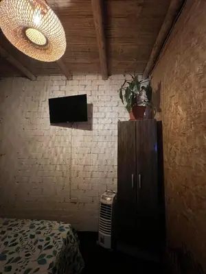 a bedroom with a bed and a tv on a wall at Tres Gatos Paracas in Paracas