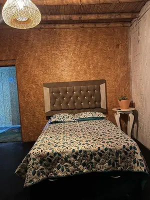 a bedroom with a bed with a comforter at Tres Gatos Paracas in Paracas