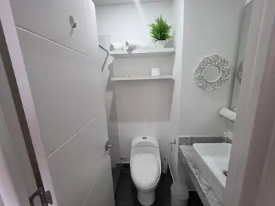 a white bathroom with a toilet and a sink at PERU STAY Barranco in Lima