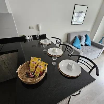 a dining room table with chairs and a table with food at Nordic Barranco by PERU STAY in Lima