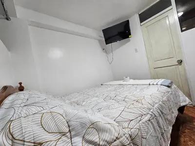 a bedroom with a bed and a flat screen tv at Pantaq hostal in Cusco