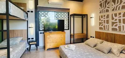 a bedroom with a bunk bed and a tv and a couch at Private 4BR Getaway with Pool & Cinema in Ica