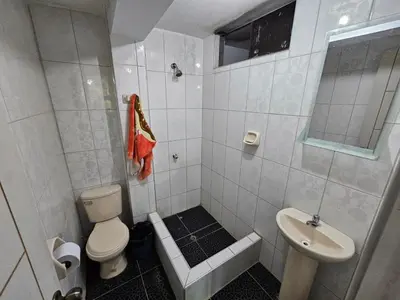 a white bathroom with a toilet and a sink at Munay Ayllu- Tu refugio familiar en Huánuco in Huánuco