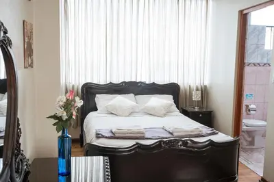 a bedroom with a black bed with towels on it at Moty's Guesthouse in Cusco