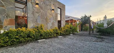 a stone building with plants next to a building at Quiet 3BR Country Villa whit BBQ in Ica