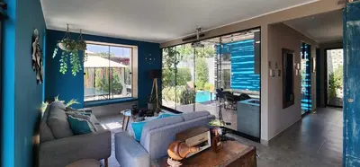 a living room with blue walls and a couch and a table at Quiet 2BR Villa whit Pool & Games in Ica
