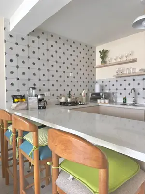 a kitchen with a counter with chairs and a counter top at Modern apartment a short walk from the boulevard and beach in Punta Hermosa