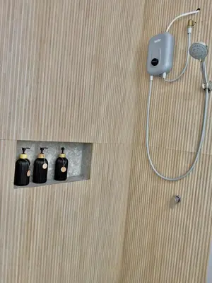 a shower in a bathroom with three black bottles at Modern apartment a short walk from the boulevard and beach in Punta Hermosa