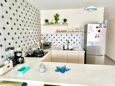 a kitchen with a refrigerator and a counter top at Modern apartment a short walk from the boulevard and beach in Punta Hermosa