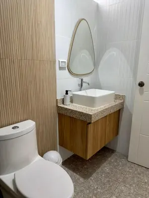 a bathroom with a toilet and a sink and a mirror at Modern apartment a short walk from the boulevard and beach in Punta Hermosa