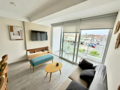 a living room with a couch and a table at Modern apartment a short walk from the boulevard and beach in Punta Hermosa