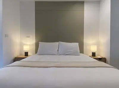 a bedroom with a white bed with two lamps at Enchanting Loft with Balcony in Barranco in Lima