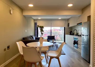 a kitchen and a living room with a table and chairs at Enchanting Loft with Balcony in Barranco in Lima