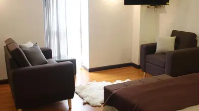 a living room with two chairs and a couch at Acogedor Departamento Vitoque in Cusco