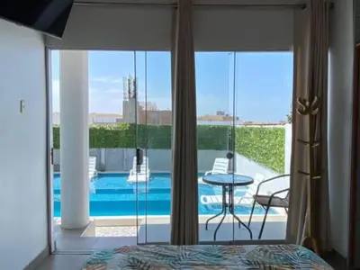 a bedroom with a bed and a view of a pool at Casa de Playa - Mara House in Huacho
