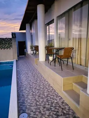 a balcony with a table and chairs next to a pool at Casa de Playa - Mara House in Huacho
