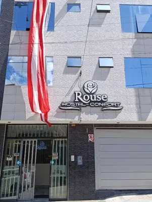 a building with an american flag in front of a garage at Rouse Hostal Confort in Huancayo