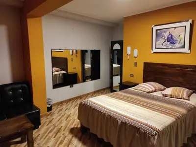 a hotel room with a bed and yellow walls at Rouse Hostal Confort in Huancayo
