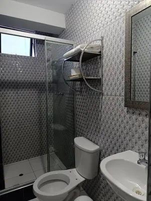 a bathroom with a shower and a toilet and a sink at Rouse Hostal Confort in Huancayo