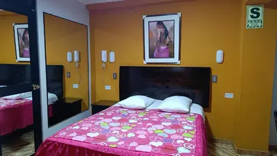 a bedroom with a bed and a large mirror at Rouse Hostal Confort in Huancayo