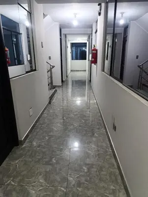 an empty hallway with a tile floor in a building at Rouse Hostal Confort in Huancayo