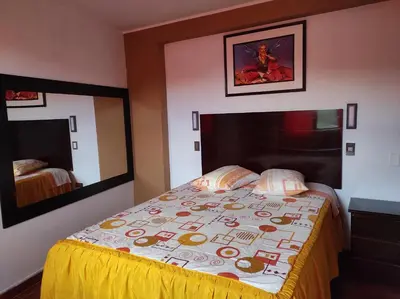 a bedroom with a bed and a large mirror at Rouse Hostal Confort in Huancayo