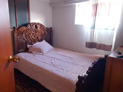 a bedroom with a large bed with a wooden headboard at El despertar del inka in Cusco