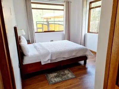 a bedroom with a bed in front of a window at Beautiful house in the Sacred Valley, Arin Falls in Calca