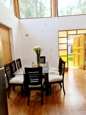 a dining room with a table with chairs and a vase of flowers at Beautiful house in the Sacred Valley, Arin Falls in Calca