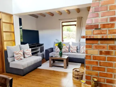 a living room with a couch and a brick wall at Beautiful house in the Sacred Valley, Arin Falls in Calca
