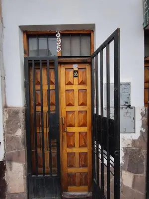 an entrance to a building with a wooden door at Mayu House Inn a minutos del centro histórico in Cusco