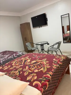 a bedroom with a bed and a table with chairs at Hotel Roma Quillabamba in Quillabamba