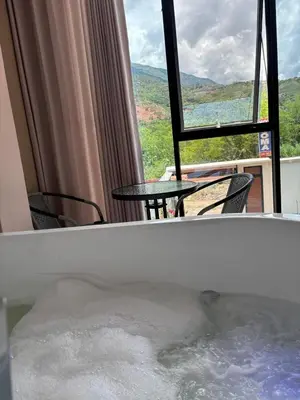 a hot tub with chairs and a table and a window at Hotel Roma Quillabamba in Quillabamba