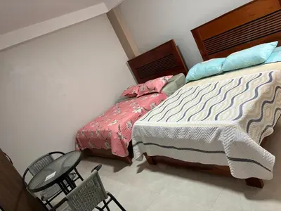 a bedroom with a bed and chairs in it at Hotel Roma Quillabamba in Quillabamba