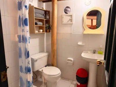 a small bathroom with a toilet and a sink at Andes Home in Cusco