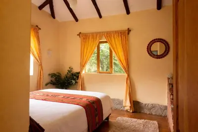 a bedroom with a bed and a window at Cabin in Inca Sanctuary in Ollantaytambo
