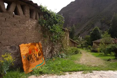 a stone wall with a sign on the side of it at Cabin in Inca Sanctuary in Ollantaytambo