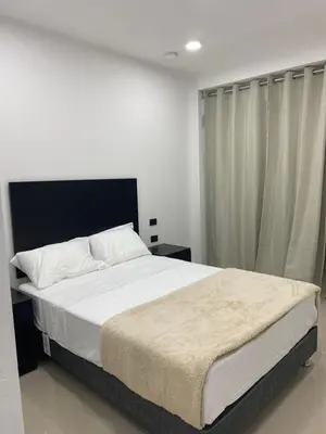 a bedroom with a large bed with white sheets at Prado hotel in Chancay