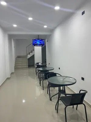 a room with tables and chairs and a television on the wall at Prado hotel in Chancay