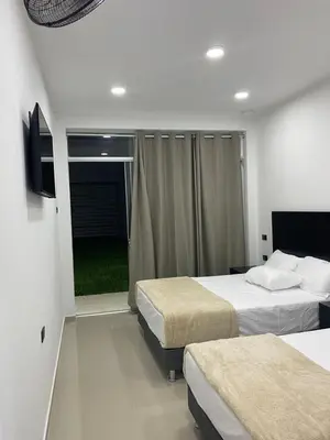 a hotel room with two beds and a television at Prado hotel in Chancay