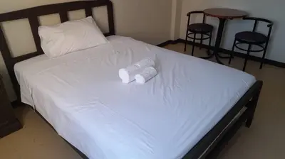 a bed with two white towels on top of it at Hotel Naciones Unidas in Lima