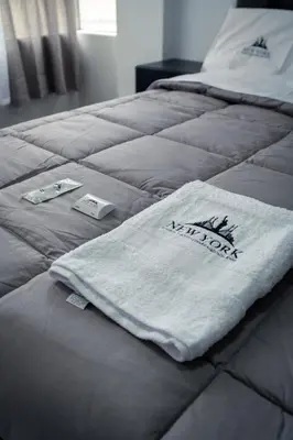 a bed with a white towel on top of it at Hostal New York in Jauja