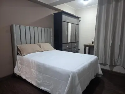 a bedroom with a large bed and a dresser at room rent in Lima